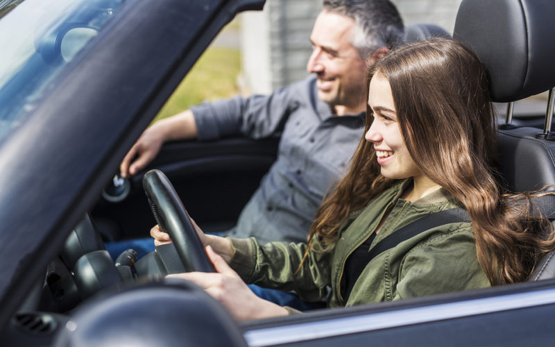 Teen girl driving with her dad