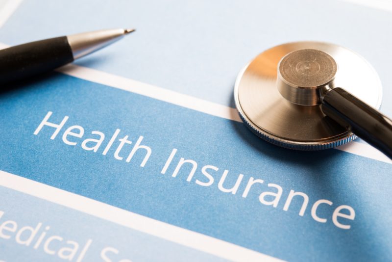 Health insurance document with pen and stethoscope