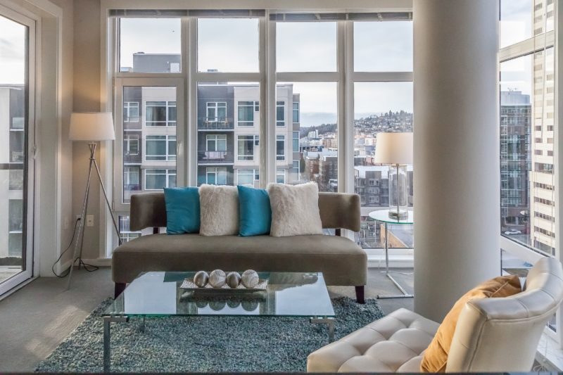 modern living room with teal accents and city view