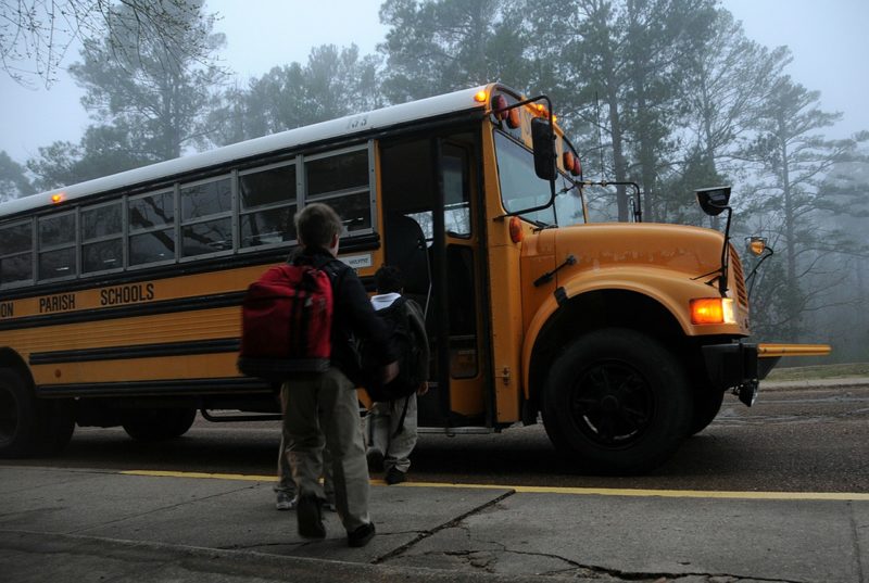 children getting on school bus