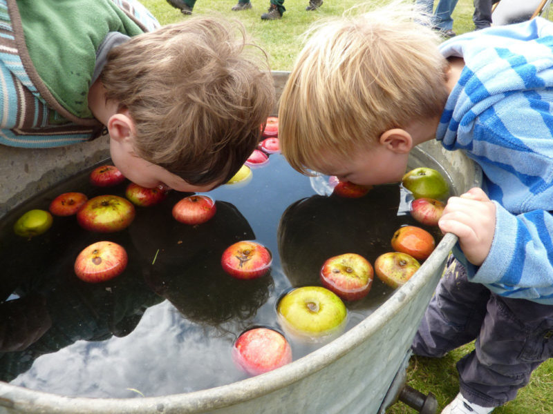 two kids bobbing for apples