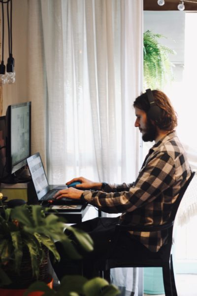 man with headphones working at desk at home